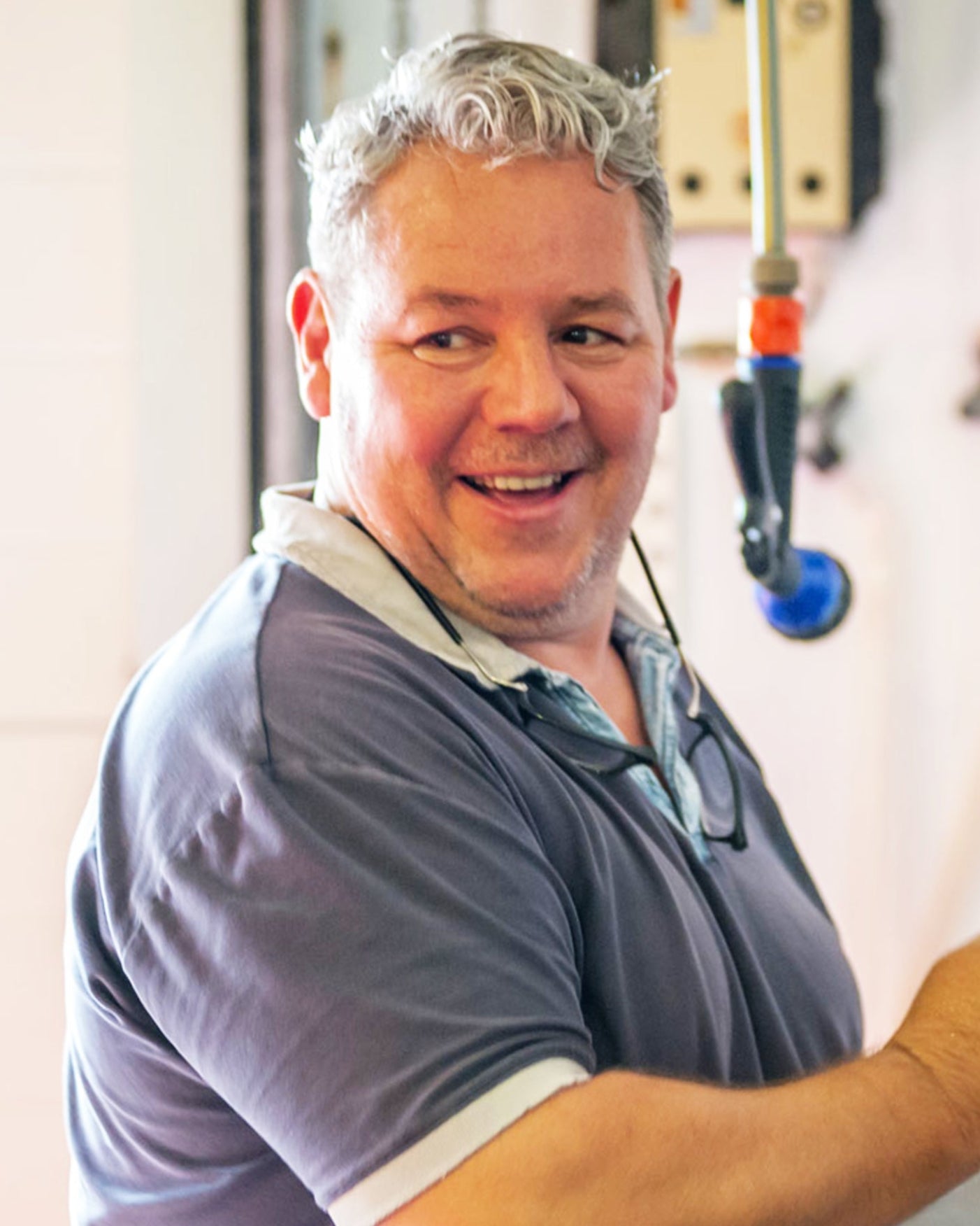 Picture of Frèdèric Cossard smiling, while apparently operating some machinery